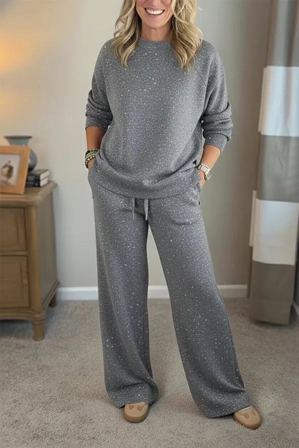 Woman wearing a grey shimmer crewneck sweatshirt and matching wide-leg pants